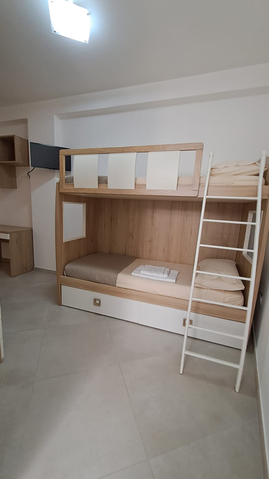 Camera con letto a castello in legno chiaro