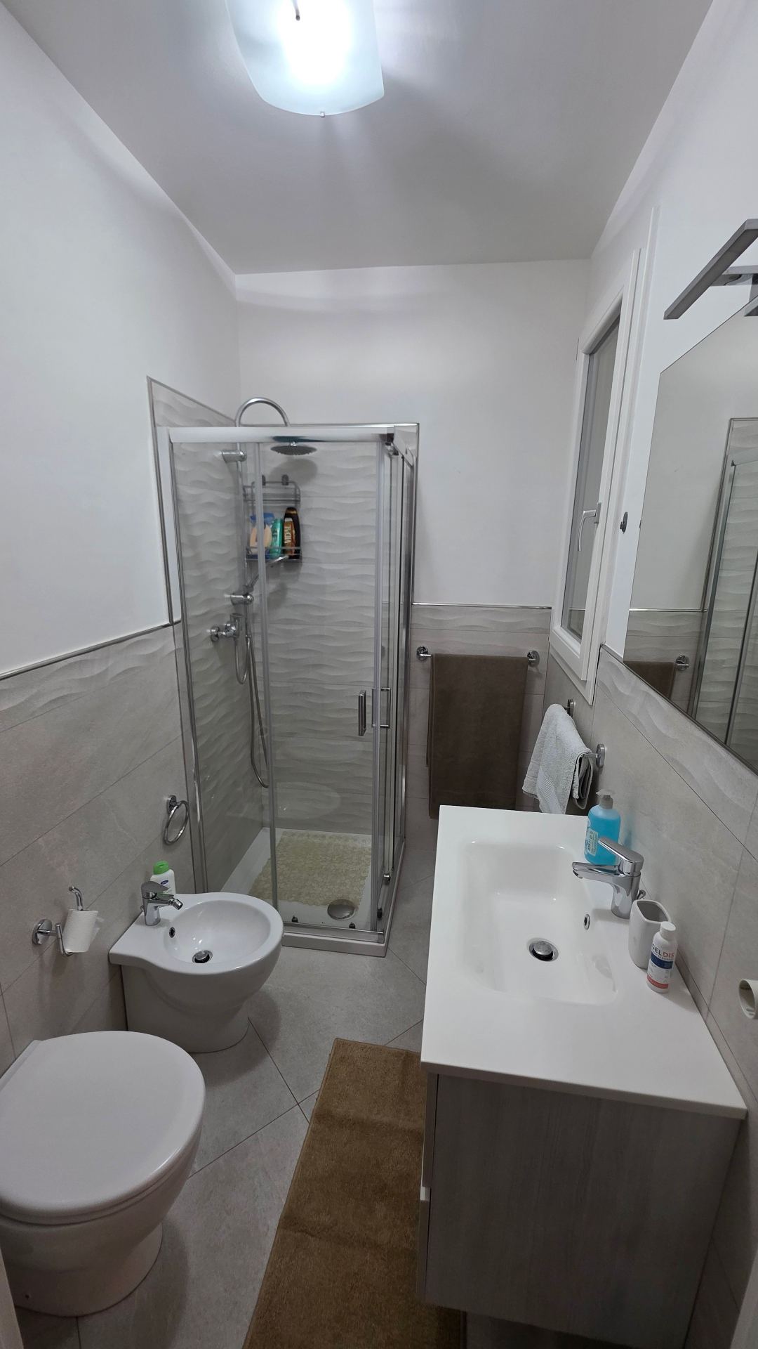 Bagno con box doccia e ampio specchio
