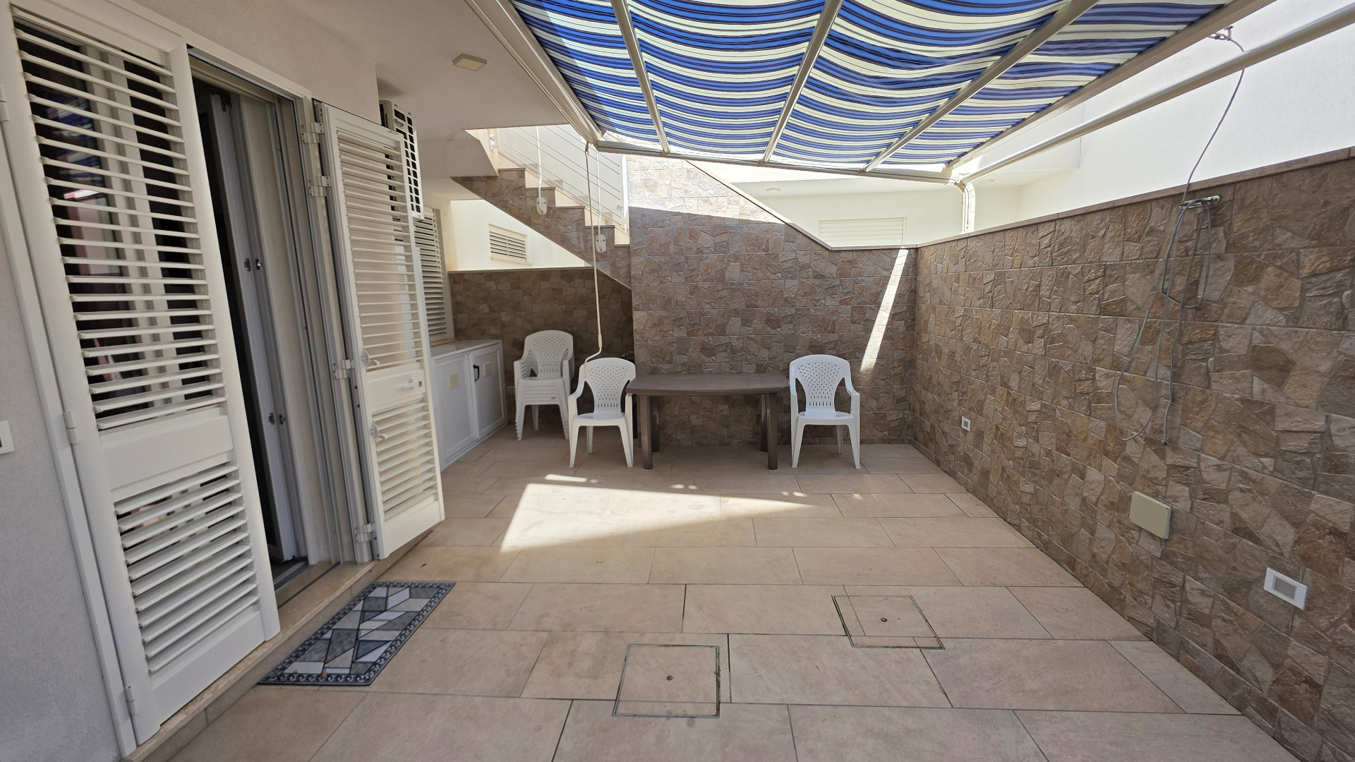 Terrazza coperta con tendaggio a righe blu